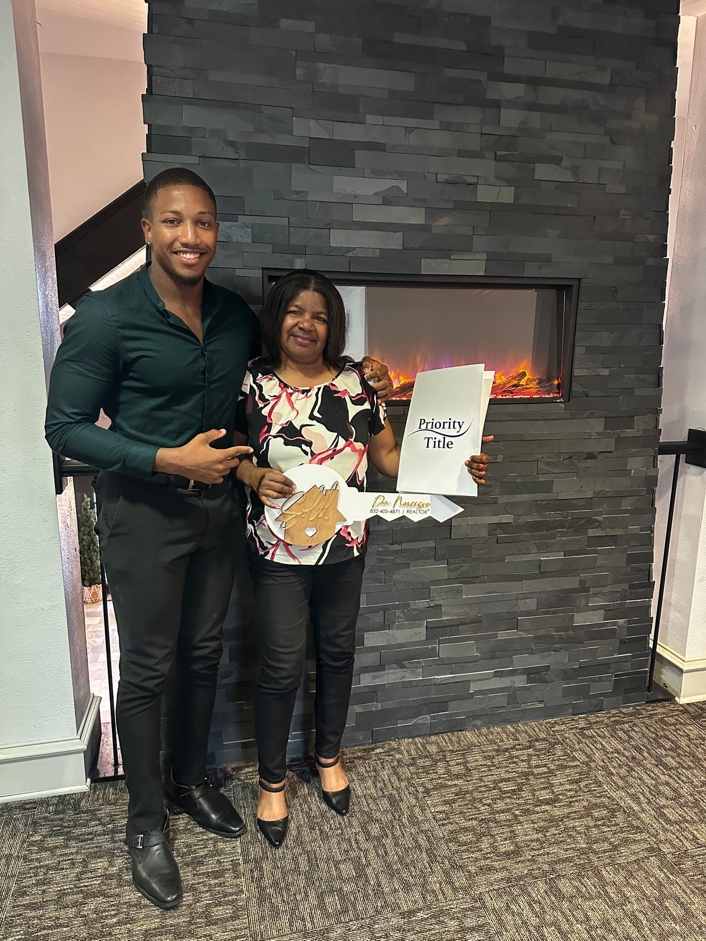 Don Narcisse with a client holding a sold key at the title office